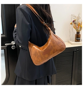 Brown vintage faux leather crescent shoulder bag with embossed fashion tag detail