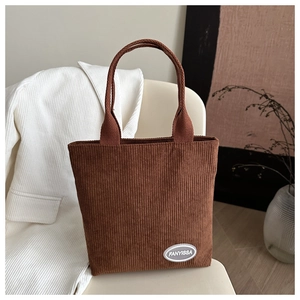 Close-up of brown corduroy tote bag featuring a textured finish and FANYISSA logo detail