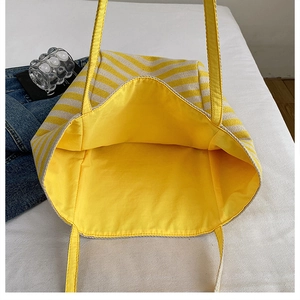 Close-up of the spacious yellow striped knit tote bag interior with durable handles