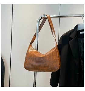 Detail of vintage brown oil wax leather bag with adjustable strap and Fashion logo