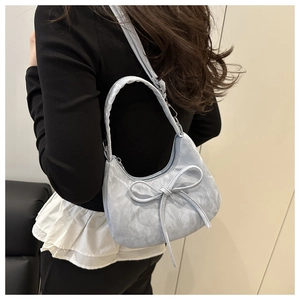 Modell mit hellblauer Schleifen-Tasche mit wolkenartiger Plissee-Struktur und Metalldetails