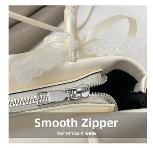 Detail of silver metal zipper and decorative lace ribbon on beige shoulder bag