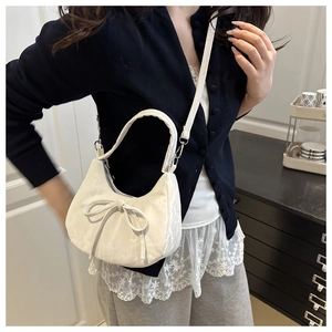 Detailansicht der cremeweißen Hobo-Tasche mit 3D-Schleifendekor und schmalem Griff