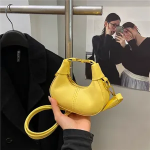 Yellow leather crescent moon bag with thin strap and gold buckle for women