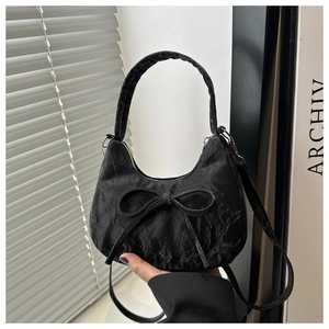Detailansicht der schwarzen Falten-Tasche mit großer Schleife und Texturdetail