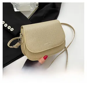 Close-up of beige woven texture saddle bag with silver metal buckle and slim strap
