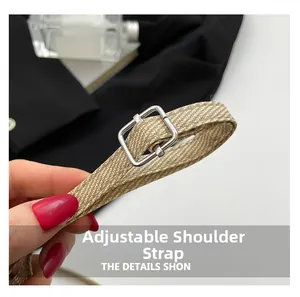 Detail view of the beige woven shoulder strap with adjustable silver square buckle