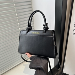 Classic black square tote bag with knotted handles and a removable crossbody strap