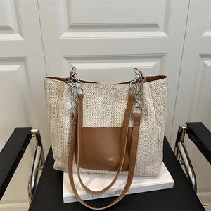 Large beige woven tote bag with brown leather pocket and metal chain strap details