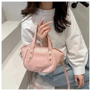 Pink leather bucket bag detail showing adjustable strap and fashion typography