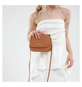 Gros plan sur un sac besace marron tissé avec logo Fashion Trend sur le rabat avant