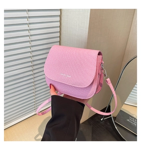 Close-up of pink textured fabric saddle bag featuring white Fashion Trend lettering