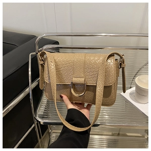 Detail van kaki crossbodytas van reliëfleer met een elegante goudkleurige D-vormige gesp