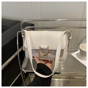 Detail van de witte PU-lederen crossbodytas met gouden D-gesp en getextureerd oppervlak