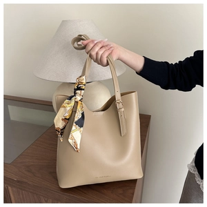 Détail du sac cabas beige avec texte de mode et écharpe imprimée décorative sur l'anse