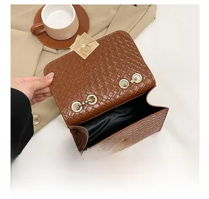 Detailansicht des braunen Webmusters und Innenfachs der Tasche mit goldenem Schloss