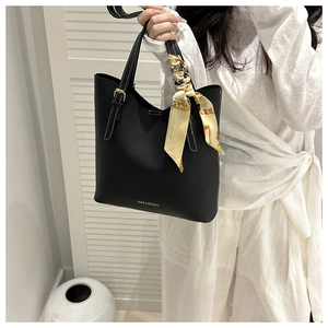 Détail du sac cabas noir avec coutures contrastées blanches et foulard en soie