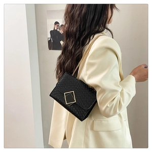 Détail du sac bandoulière en cuir tressé noir avec fermoir doré et bandoulière chaîne