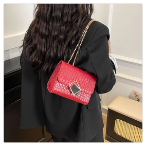 Vue détaillée du sac bandoulière rouge en similicuir avec chaîne dorée sur mannequin