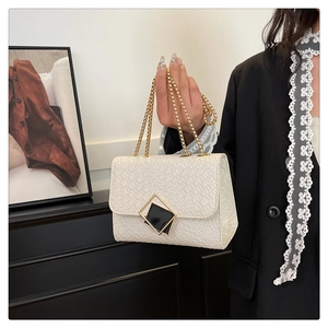 Détail du sac à main blanc en cuir gaufré avec fermoir doré et bandoulière chaîne