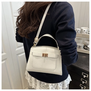 Gros plan d'un sac bandoulière blanc en cuir grainé avec un fermoir doré rotatif élégant