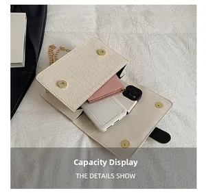 Interior capacity display of cream faux crocodile leather bag with golden chain