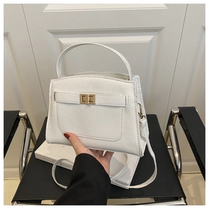 Vue détaillée du sac à main en cuir grainé blanc avec fermoir doré et poignée chic