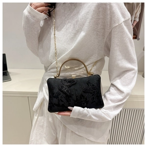 Detail of black lace crossbody bag with 3D butterfly appliques and gold chain strap
