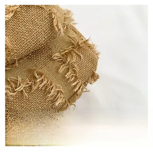 Detail shot of coarse linen square bag featuring frayed fringe edges and woven texture