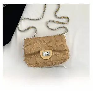 Detailed close-up of khaki denim texture and silver twist lock on chain crossbody bag