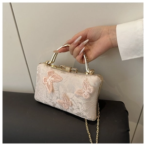 Detail of elegant evening bag with 3D butterfly embroidery and gold handle