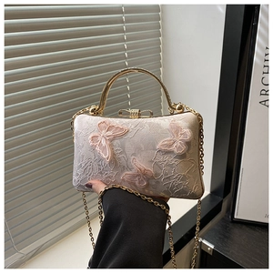 Detail of embroidered lace crossbody bag with pink 3D butterfly appliques and gold handle