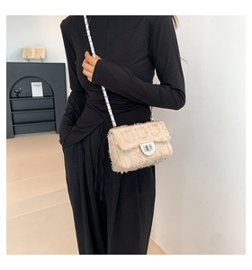 Beige tweed crossbody bag featuring silver metal twist lock and woven chain strap on model