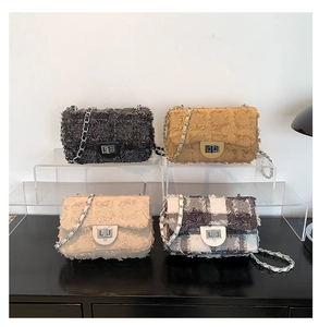 Detailed display of four textured fringe chain crossbody bags with metal turn locks