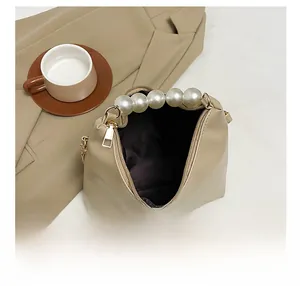 Macro view showing the spacious dark lining and gold zipper of this pearl handle bag