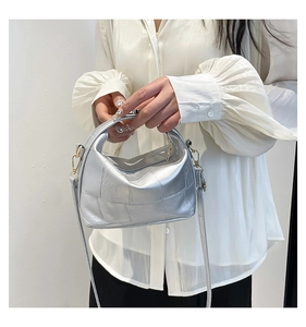 Detail of silver geometric patchwork handbag with metallic texture and thin strap