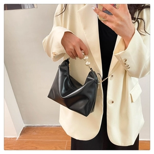 Chic black mini dumpling bag with faux leather finish and elegant pearl handle strap