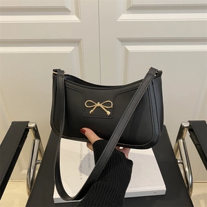 Minimalist black crescent shoulder bag with golden butterfly buckle for women