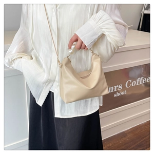 Detail showing creamy beige hobo bag with large pearl handle and thin cross-body strap