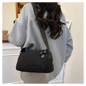 Detailed back view of a woman wearing the black lightweight nylon crossbody bag outdoors