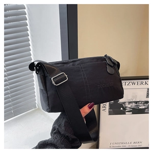 Detail of black nylon shoulder bag with adjustable wide strap and DUONING logo