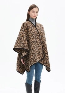 Detail of thick leopard print shawl with black trim paired with stylish winter outfit