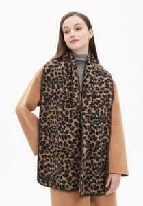 Detail of soft leopard print thick knit scarf worn with a stylish winter wool coat