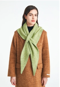 Detail view of grass green knitted wool triangle scarf styled with a brown wool coat