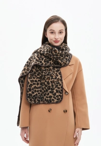 Close-up of winter leopard print scarf with lock-stitched edges on camel wool coat
