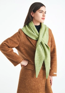 Detail showing the thick knit texture of the light green triangle wool scarf on a brown coat