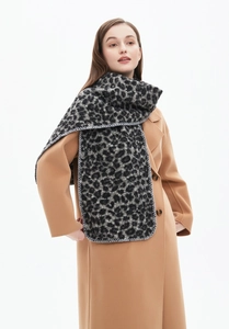 Detail shot of leopard print scarf with premium overcast stitching on soft winter fabric