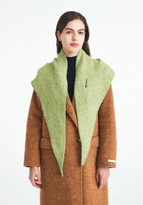 Close-up of light green knit wool shawl paired with a dark brown wool coat for winter