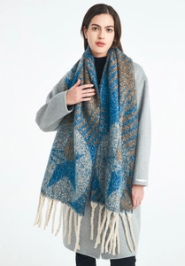Detail of soft jacquard scarf featuring blue leaf patterns and thick cream fringe tassels