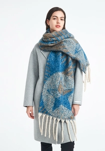 Detail of star jacquard boucle yarn scarf featuring thick tassels and heavy winter texture